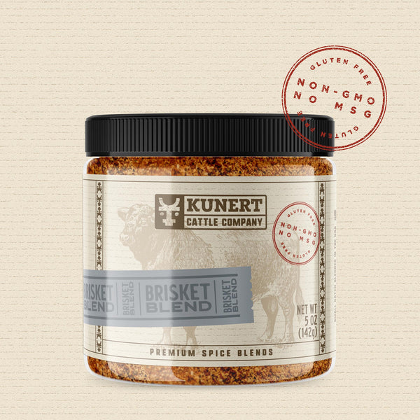 A 5 oz jar of Kunert Cattle Company: Brisket Blend seasoning. The label features the company logo, on a cream background superimposed with a cow, with a blue-gray insert containing the subheading “Brisket Blend” in block letters. The label also contains the claims “gluten-free, non-GMO, no MSG.”