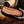 A person holding up a cross-section of cooked brisket.